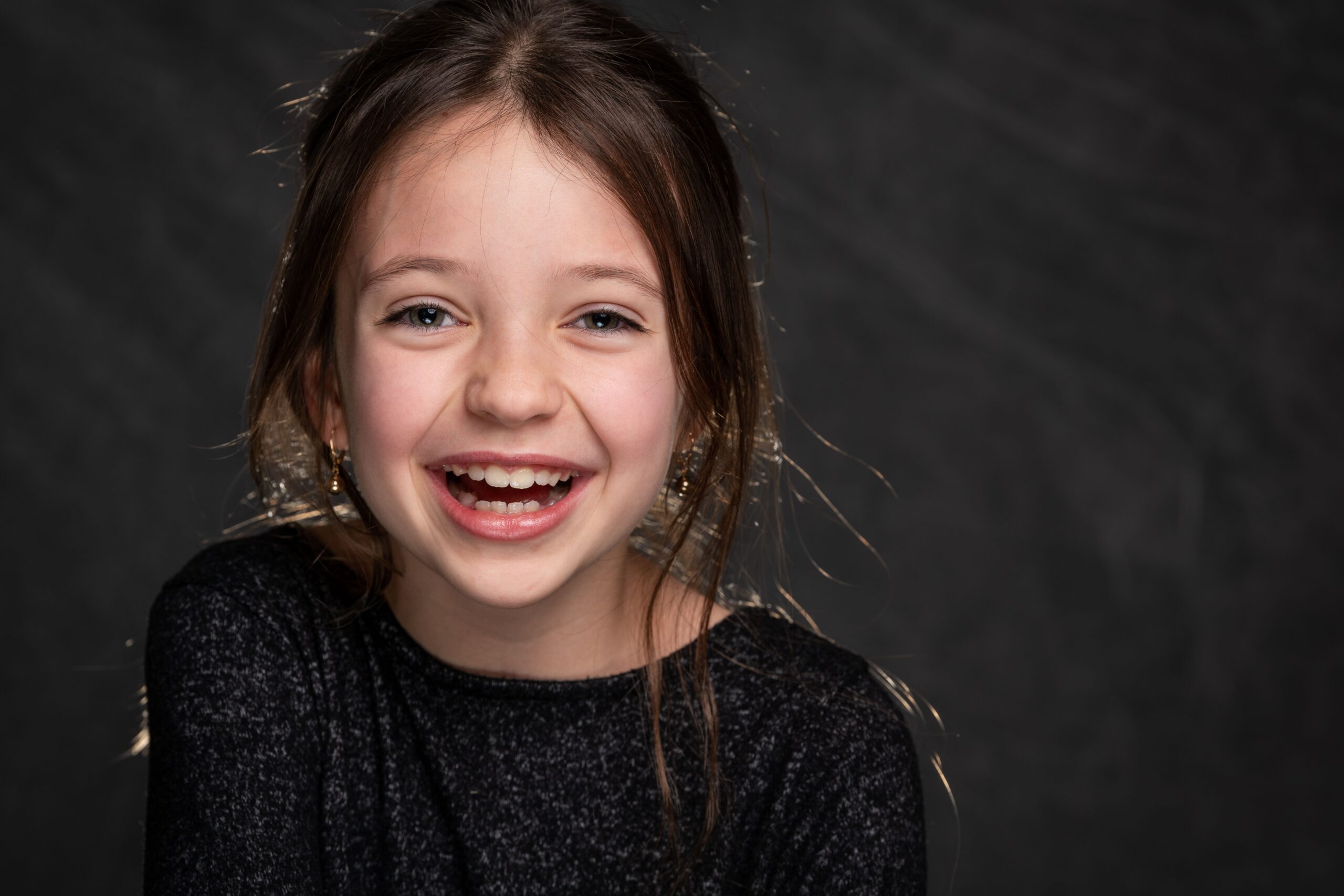 Portrait d'une jeune fille souriante sur fond sombre